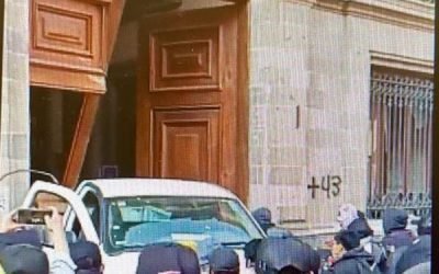 Manifestantes de Ayotzinapa irrumpen y derriban puerta del Palacio Nacional