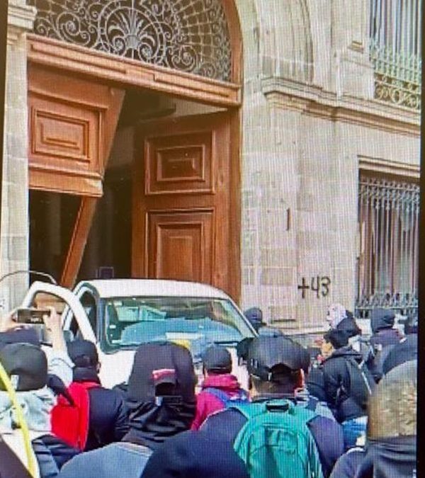 Manifestantes de Ayotzinapa irrumpen y derriban puerta del Palacio Nacional