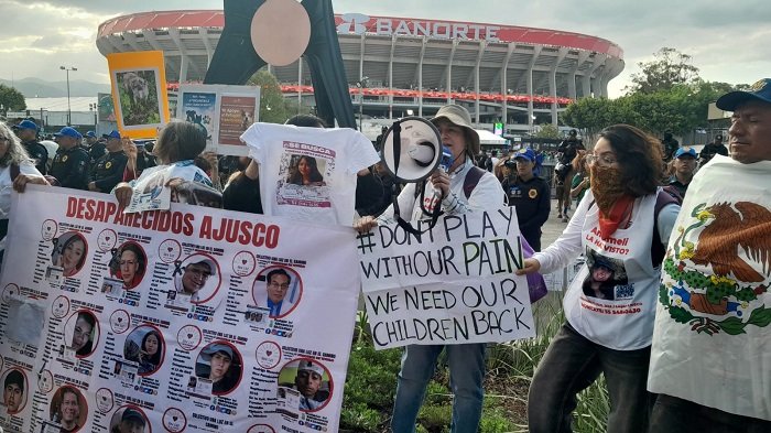 Madres buscadoras protestan con mantas afuera del Estadio Banorte